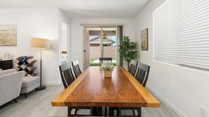 A dining area with a wooden table, chairs, a floor lamp, and a bookshelf. - Game Day Stay - Community Pool Access + Walk to Stadium + Close to Westgate (Glendale)