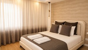 A hotel room with a large bed, a headboard, and a curtain. - Lovely & Comfy I - Checkinhome (Monte Estoril)