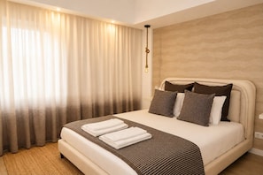 Ein Hotelzimmer mit einem großen Bett, einem Kopfteil und einem Vorhang.