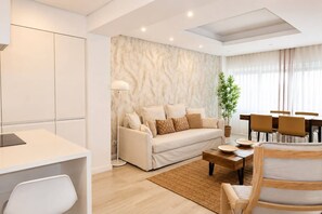 Ein modernes Wohnzimmer mit Sofa, Couchtisch und Essbereich.