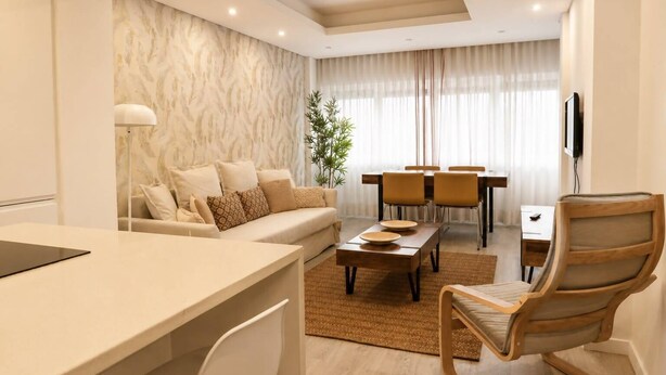 A modern living room with a sofa, coffee table, dining table, chairs, and a TV. - Lovely & Comfy I - Checkinhome (Monte Estoril)