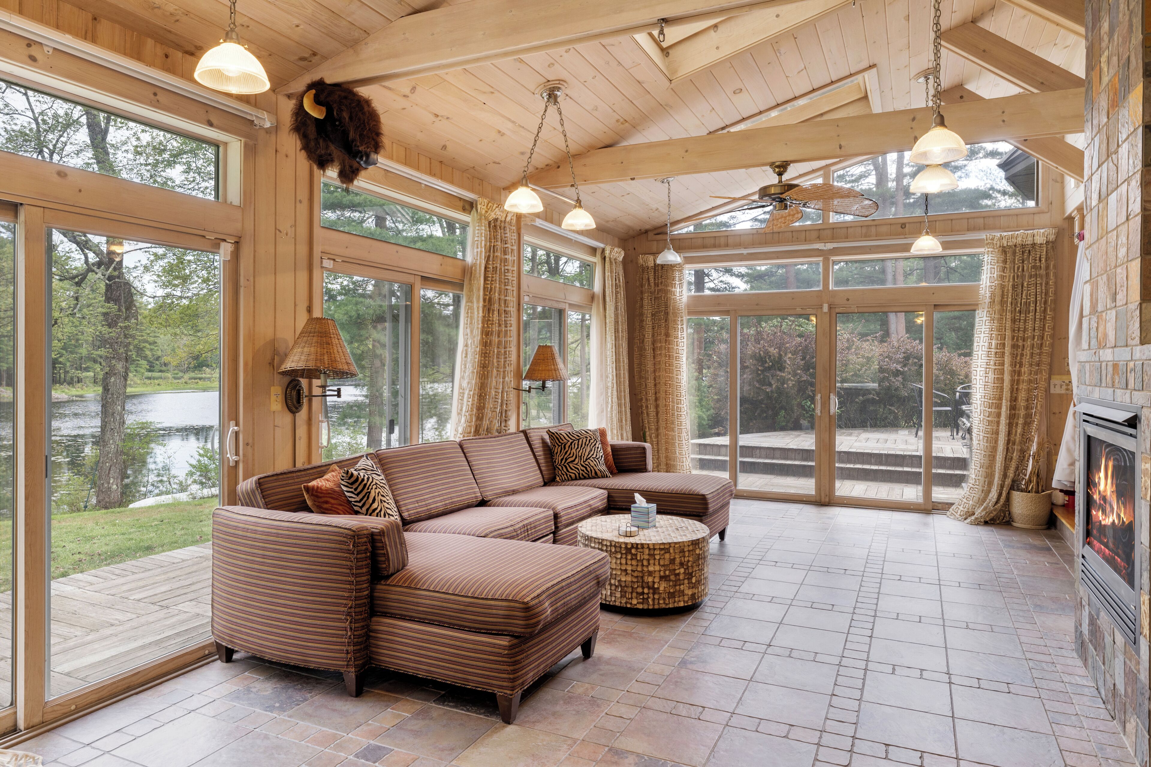 A spacious living room with a large sectional sofa, a round coffee table, and a fireplace.