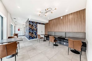 A modern restaurant with a geometric wall pattern, a wooden panel wall, and a seating area with tables and chairs. - Downtown Condo, Stylish & Comfy (Calgary)