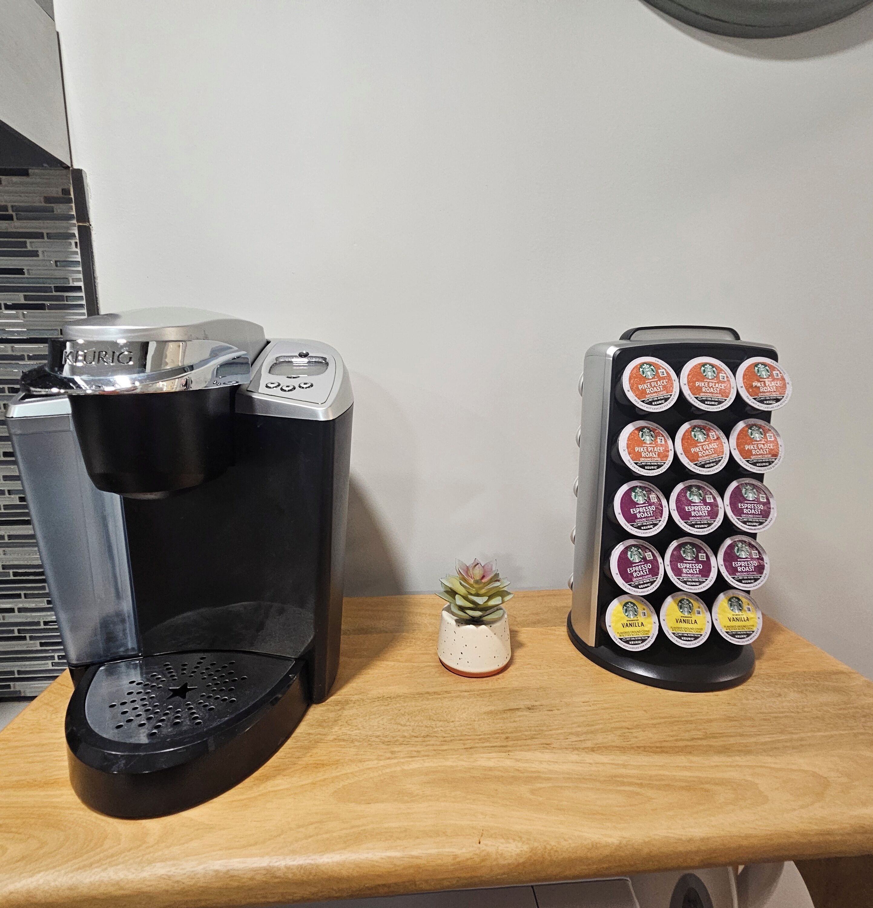 Una macchina da caffè e un contenitore per cialde da caffè su un tavolo di legno.