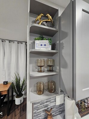 A white shelving unit with decorative items, including a mixtape box, two golden bird figurines, and three glass vases. - Sundown Escape-South Shore Long Island (Bay Shore)