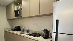 Una cocina moderna con un refrigerador de acero inoxidable, una estufa a gas y armarios empotrados.