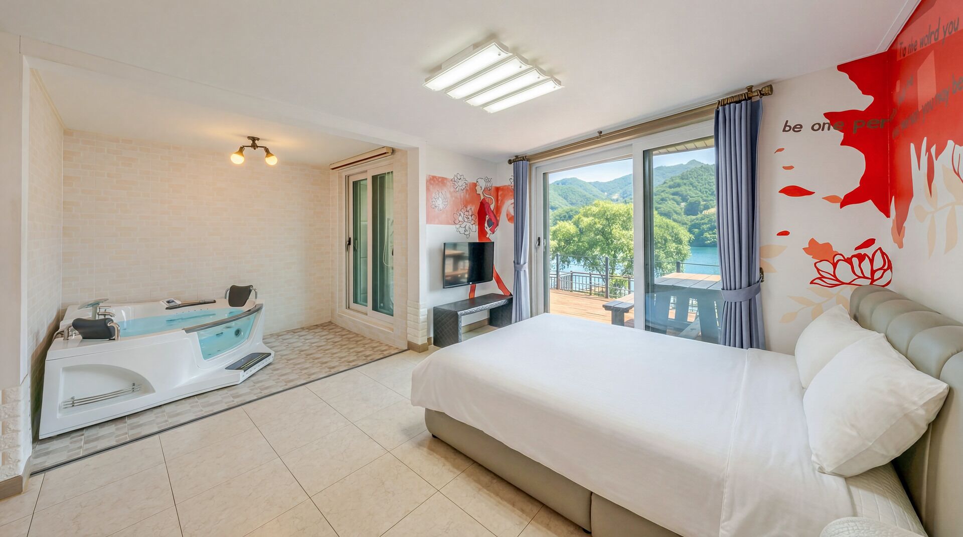 A hotel room with a bed, a bathtub, a TV, and a balcony with a view.