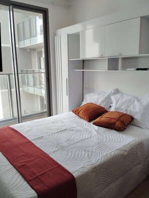 Ein Schlafzimmer mit einem Bett, einem Fenster und einem weißen Kleiderschrank.