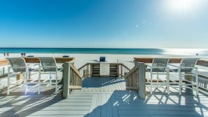 A wooden deck with white chairs leading to a beach. - Sundestin 105 (Destin)