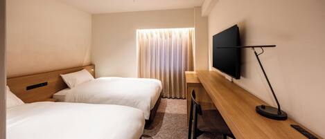 A hotel room with two beds, a desk with a chair, a flat-screen TV, and a window with curtains.