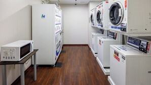 A laundry facility with multiple washing machines and dryers, a microwave, and a refrigerator. - JR Clement Inn Takamatsu Hyogomachi (Takamatsu)