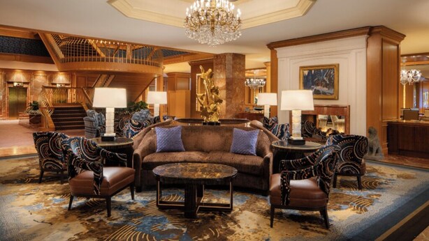 A spacious lobby with a grand staircase, a chandelier, and a seating area with patterned chairs and a brown sofa. - Charming Room w/ Pool Access, Ideal for University of Utah Visitors (Salt Lake City)