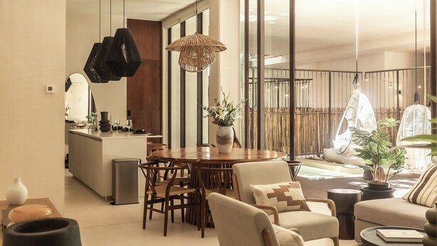 Uma sala de estar moderna com área de jantar, janelas amplas e vista para o exterior.