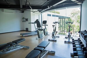 Ein Fitnessraum mit Laufbändern, Herz-Kreislauf-Geräten und Gewichten.