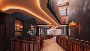 Un interior modern amb una escala corba, panells de fusta i il·luminació empotrada.