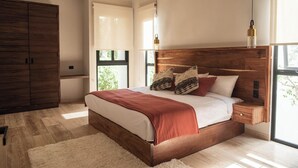 Une chambre moderne avec un grand lit, une tête de lit en bois et une vue sur la verdure.