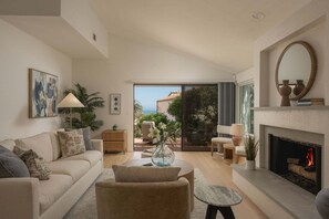 A living room with a sofa, coffee table, and fireplace. - Designer Mesa Escape with Stunning Ocean Views (Santa Barbara)