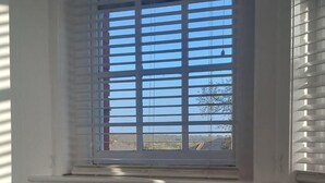 A room with a window, a round table, and two chairs. - Apartment Sleeps 2 with Parking & Garden (Greater London)