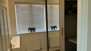 A room with a window, a radiator, and a door. - House Sleeps 8 with WiFi (Darthford)