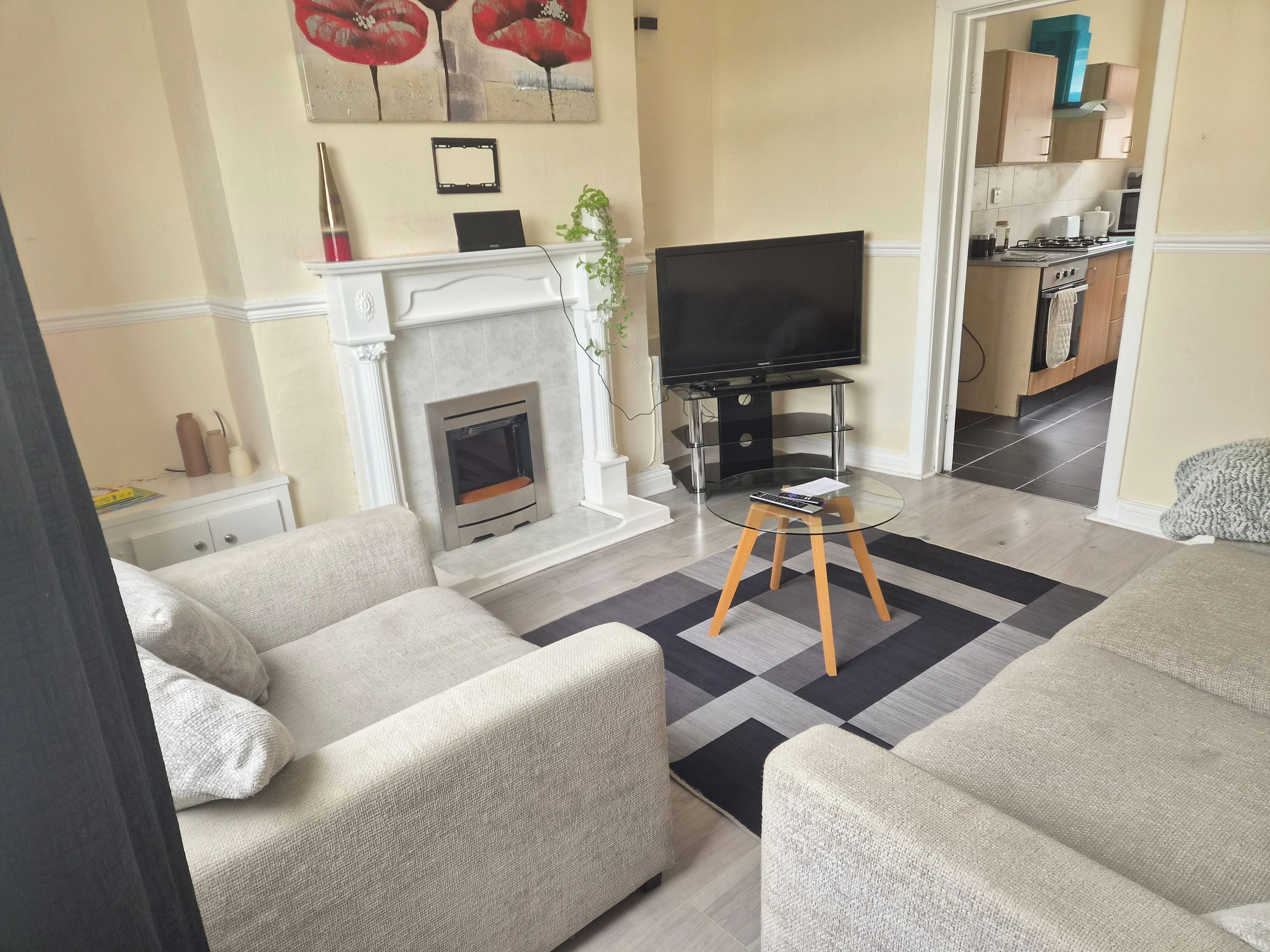 A living room with a fireplace, television, and sofas.