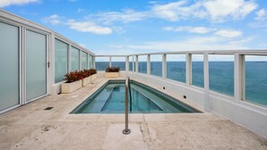 A rooftop pool with glass railings, a clear view of the ocean, and potted plants. - Tresor 2-3702 (Miami Beach)
