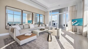 A modern living room with a large sectional sofa, a coffee table, and a TV. - Tresor 2-3702 (Miami Beach)
