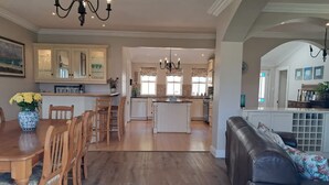 Una cocina amplia con armarios de madera, un comedor con mesa y sillas, y una sala de estar con sofá.