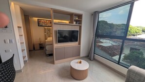 A modern living room with a TV, a round coffee table, and a sofa. - Comfortable private apartment near the Tennis Club in Cali salsa city with AC. (Cali)