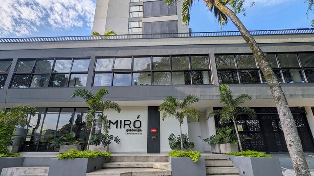 A modern building with a sign reading 'MIRÓ guadaloupe,' a staircase leading to the entrance, and surrounding greenery. - Comfortable private apartment near the Tennis Club in Cali salsa city with AC. (Cali)