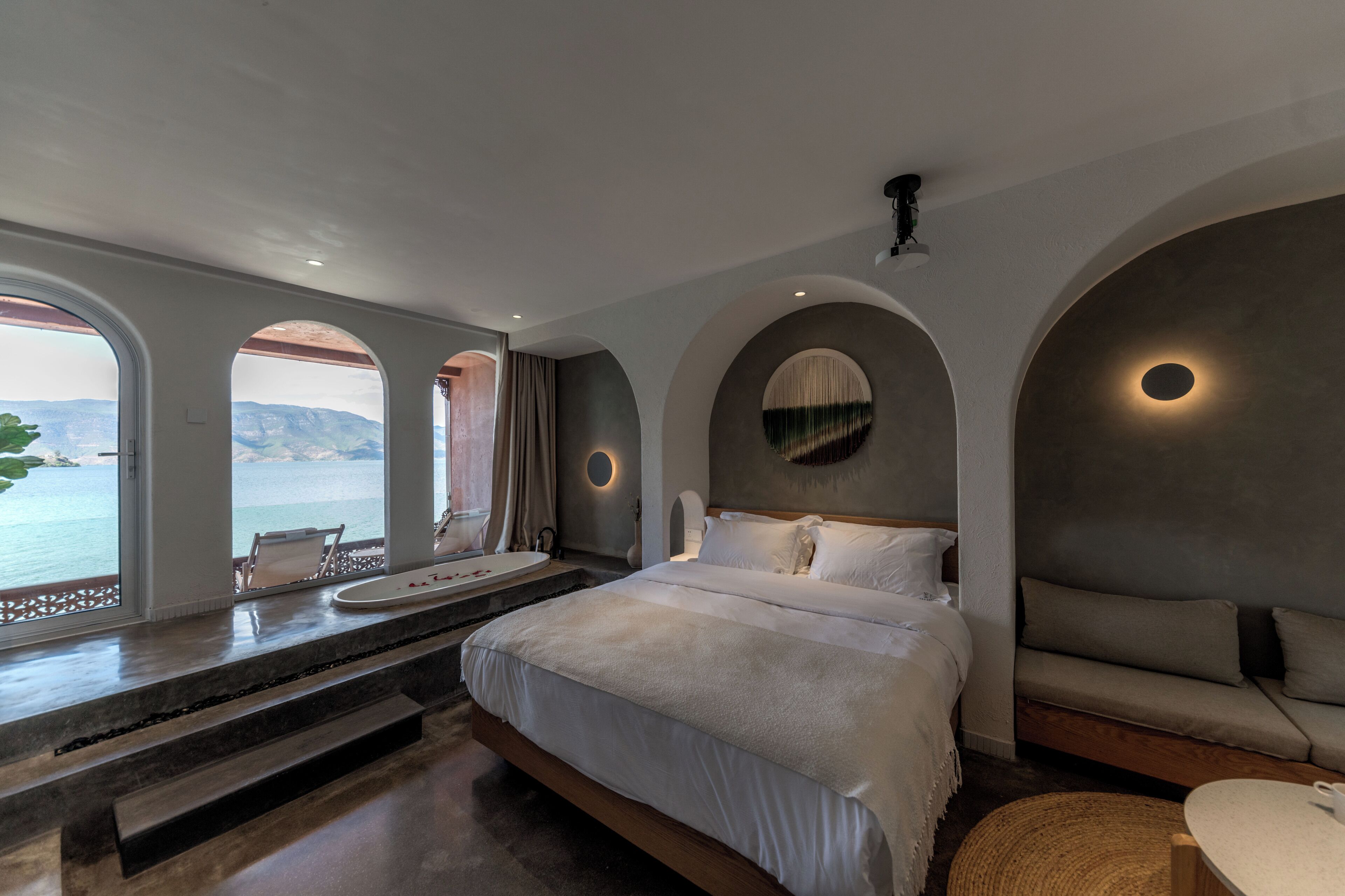 Une chambre avec un grand lit, un canapé et une vue sur la mer.