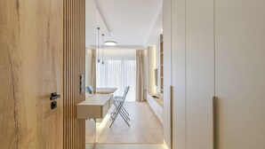 Ein modernes Interieur mit einer Holzvertäfelung, einer Essecke mit Tisch und Stühlen sowie einem eingebauten Fernsehregal.