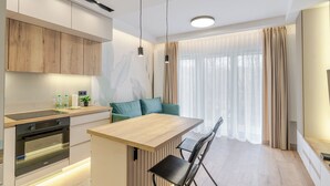 Eine moderne Küche mit Holztischplatte, integriertem Backofen und einem Essbereich mit Holztisch und Stühlen.