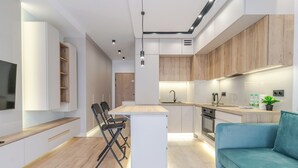 Eine moderne Küche mit Holzausstattung, einer zentralen Kochinsel und einem blauen Sofa.