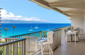 A balcony with a view of the ocean, a table, and chairs. - 8th Floor 2BR Corner Suite with Oceanview Balcony (Lahaina)