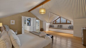 A bedroom with a large bed, a wooden ceiling, a window, and a view of a balcony. - Toi Point Lodge - A rural luxury villa inspired by the charm of a historic stone farm building. (Queenstown)