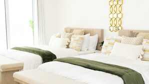 Een hotelkamer met twee bedden, een bankje en een decoratief wandobject.