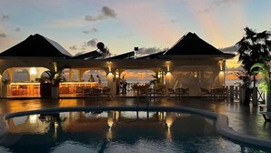 Een resort met een zwembad, terras en overdekt gedeelte.