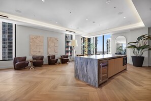 A spacious living area with a marble island, leather sofas, and a large potted plant. - 501-3110 Luxury Ocean View from Balcony Rooftop Pool & GYM (Miami)