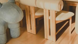 A wooden dining table with a white cushioned bench. - Shonan Minpaku Kabigon (Chigasaki)