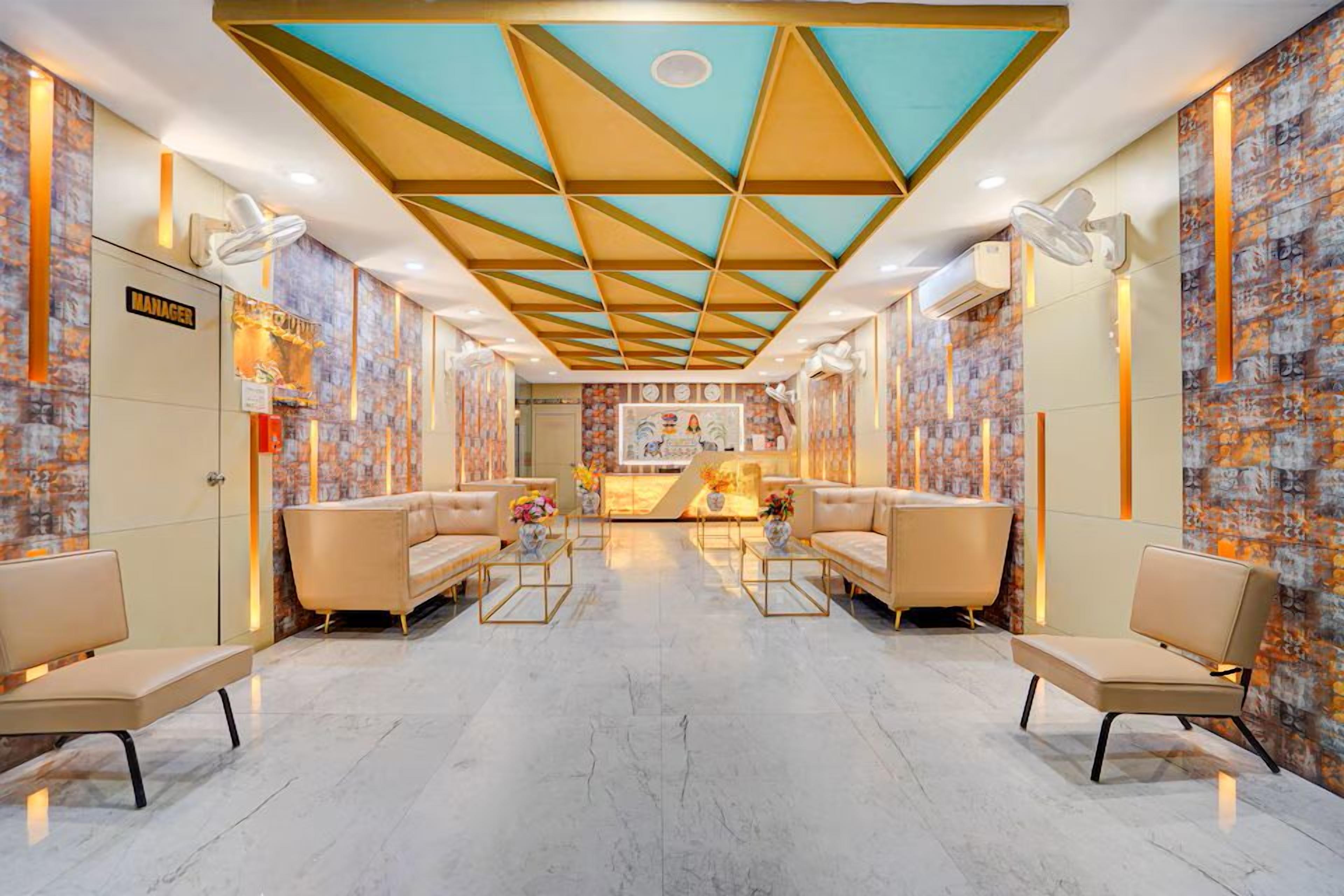 Een hotel lobby met een geometrisch plafondontwerp, zithoeken en een receptiebalie.