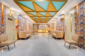A hotel lobby with a geometric ceiling design, seating areas, and a reception desk. - Amar Resorrt Motihari Bihar (Motihari)