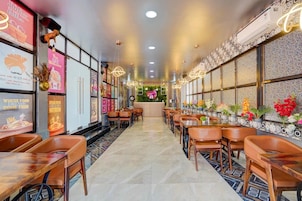 Un restaurante con una barra alargada, varias zonas de estar y elementos decorativos en las paredes.