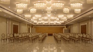 A spacious hall with rows of chairs, ornate chandeliers, and a polished floor. - Amar Resorrt Motihari Bihar (Motihari)