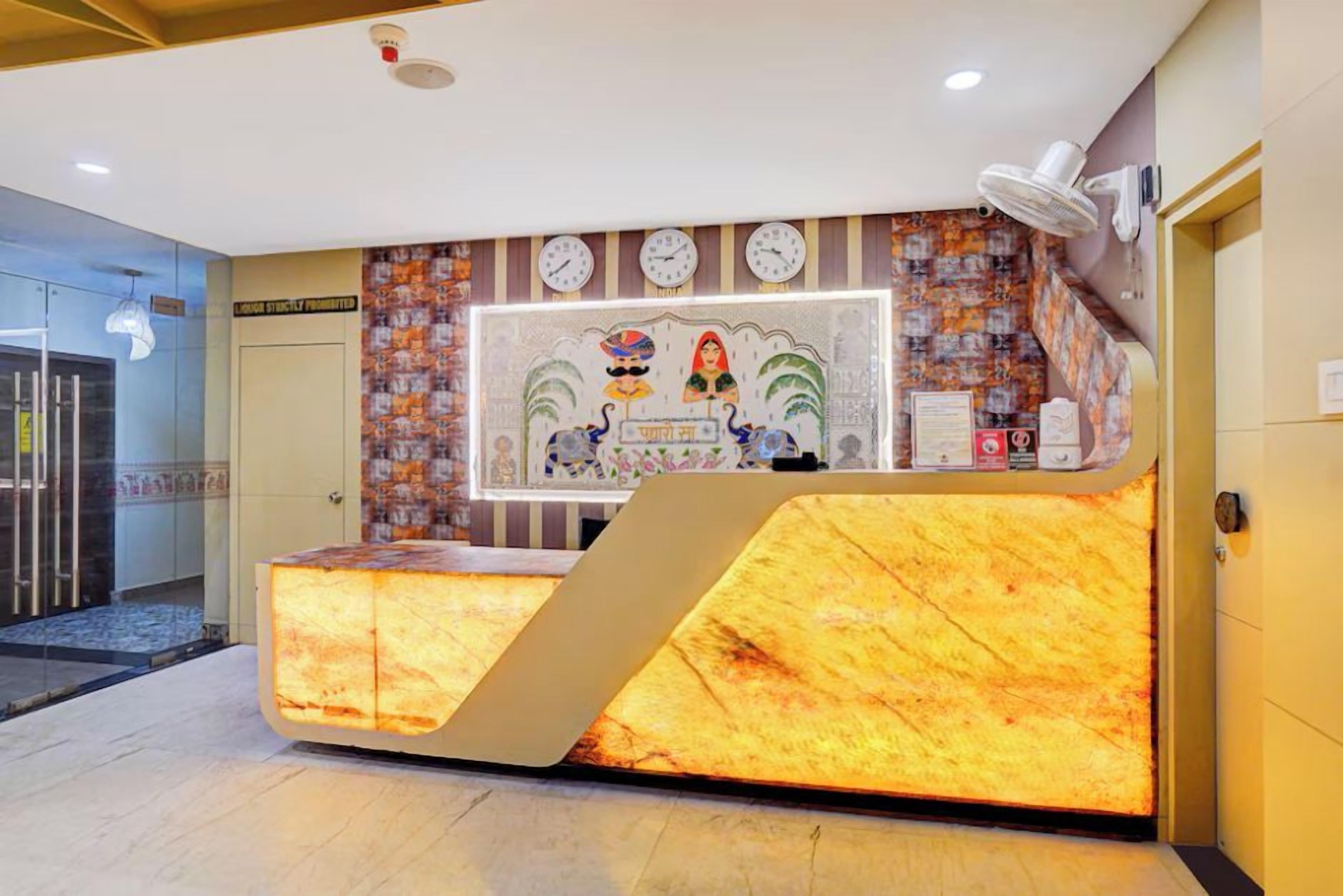 A hotel reception desk with a modern design, a clock, and a decorative wall.