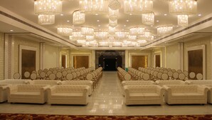 A hotel lobby with rows of white sofas, chandeliers, and a patterned carpet. - Amar Resorrt Motihari Bihar (Motihari)