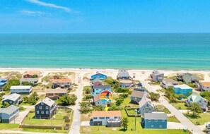 A coastal residential area with houses, a beach, and a clear sky. - Catch a Vibe! Oceanside home 4 lots from beach. Updated with timeless OBX charm! (Nags Head)