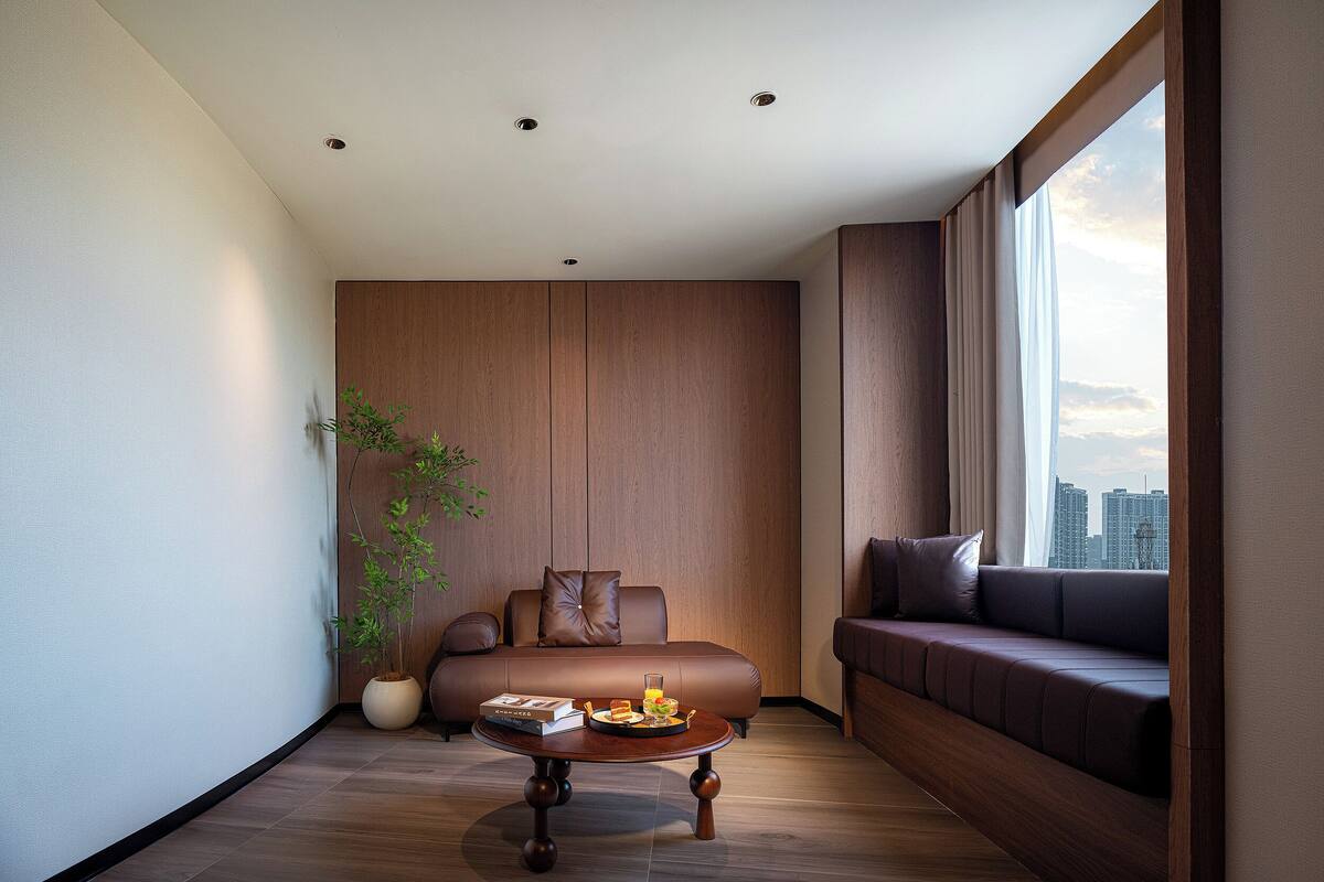 A modern living room with a sofa, a coffee table, and a potted plant.