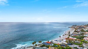 Ein Küstenort mit Strandhäusern, wolkenlosem Himmel und Blick auf den Ozean.