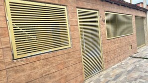 Un edificio con varias ventanas y persianas horizontales.