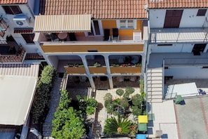 A multi-story building with balconies, a courtyard with plants, and a tiled roof. - Cute Studio Vrsar 7 With Terrace, Vrsar, Croatia (Vrsar)